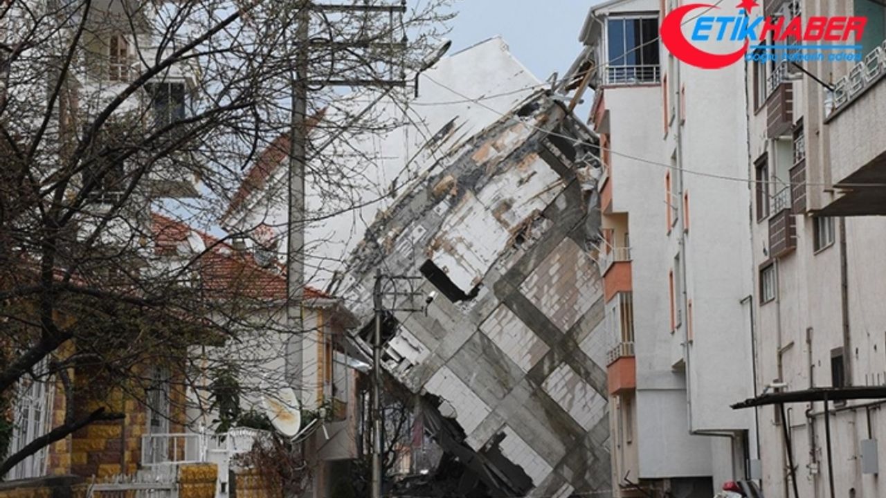 Depremde camları dahi kırılmadan yan yatan binanın yıkımı sürüyor