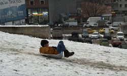 Erzurum'da kar yağışını fırsat bilen çocuklar mahalle aralarında poşet ve kızakla kaydı