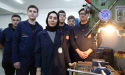 Kadın öğretmen torna tezgahında öğrencilerine üretimi öğretiyor