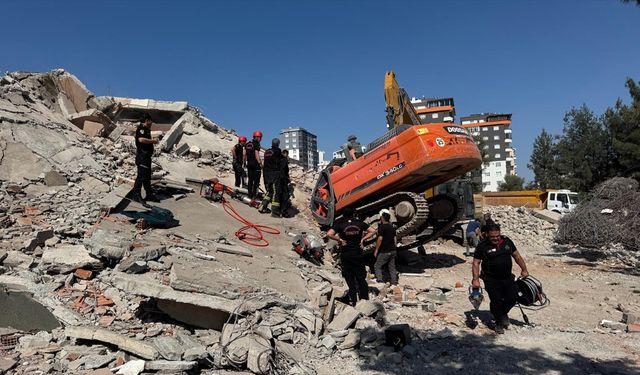 Kahramanmaraş'ta ağır hasarlı bina yıkılırken iş makinesinin üzerine devrildi