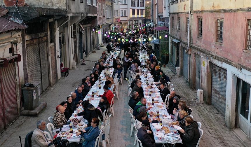 Mahalleli fazladan yaptığı yemekleri sokakta kurulan iftar sofrasında paylaşıyor